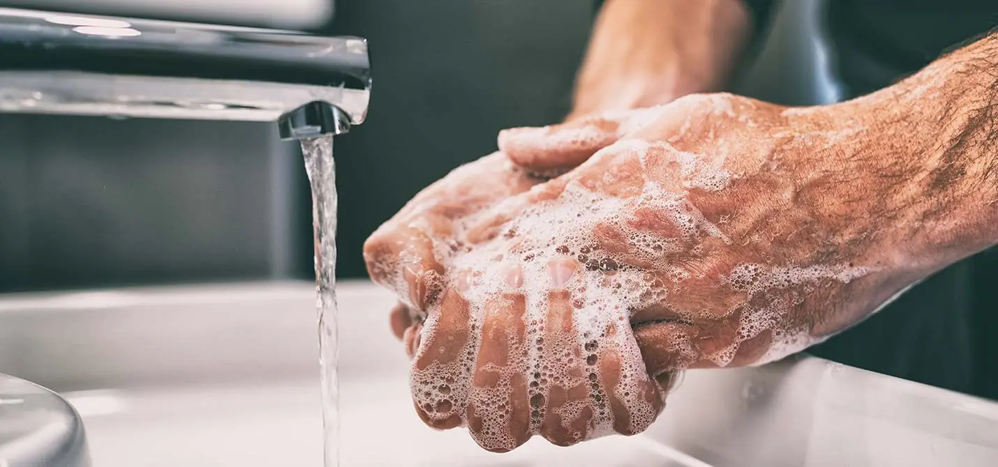 Eau usée ménagère suite au lavement des mains d’un homme avec du savon