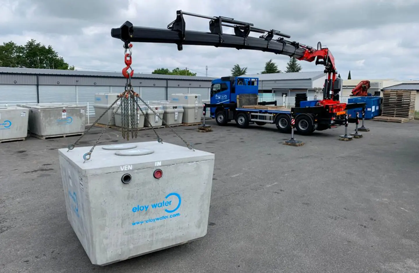un camion soulève une cuve avec des chaines