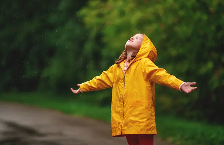 enfant sous la pluie avec manteau jaune