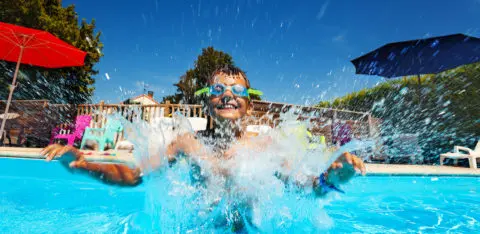 enfant qui joue dans les eaux d'une piscine de camping