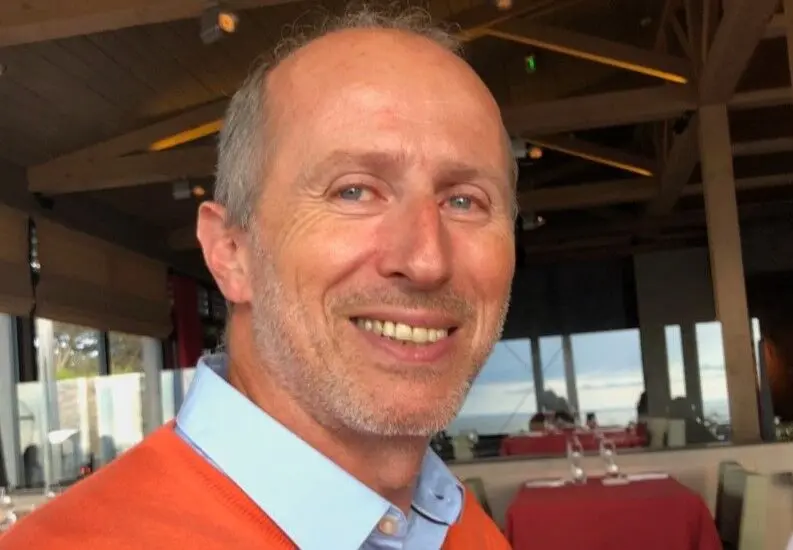 dirigeant d'eloy-aquarana souriant à la caméra avec un pull orange