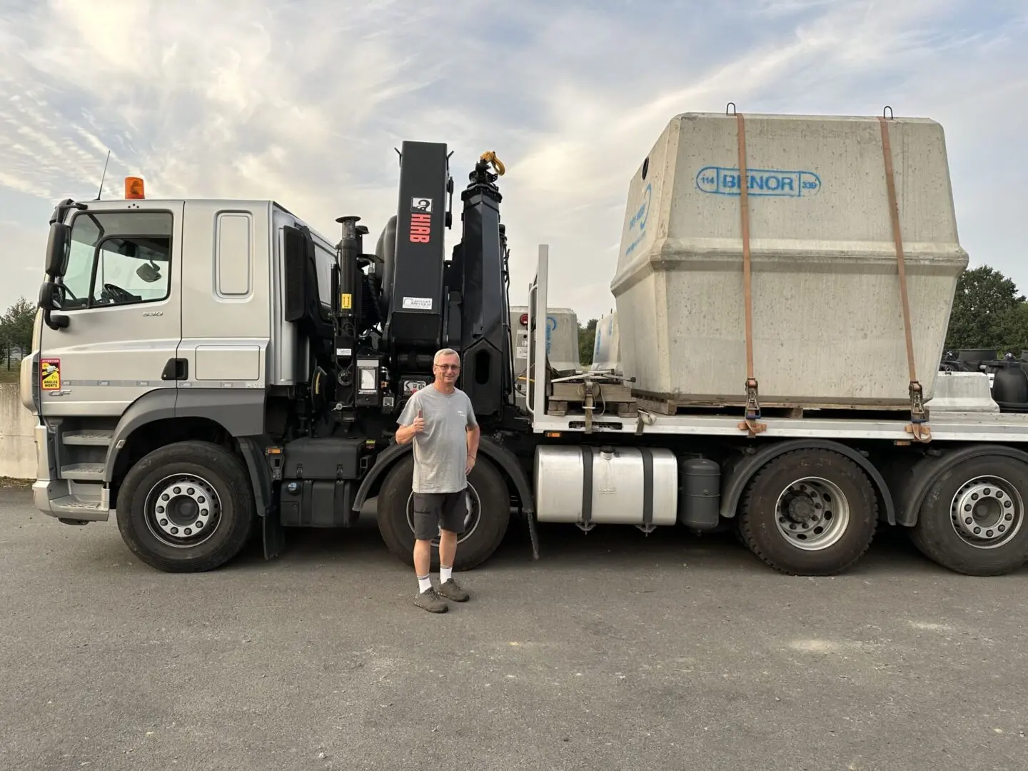 un ouvrier d'eloy-aquarana devant un camion chargé d'une cuve