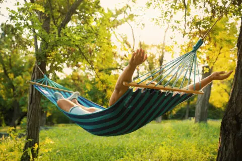 une personne profitant sur un hamac dans son jardin