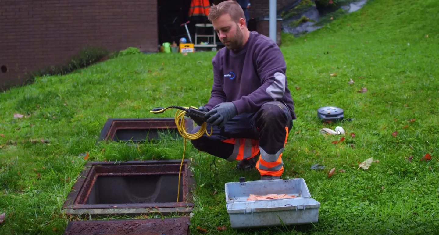Technicien certifié eloy effectuant l’entretien d’une microstation oxyfix® installée dans le jardin d’une maison individuelle. Il mesure le pH et le taux d’oxygène du dispositif d’assainissement.